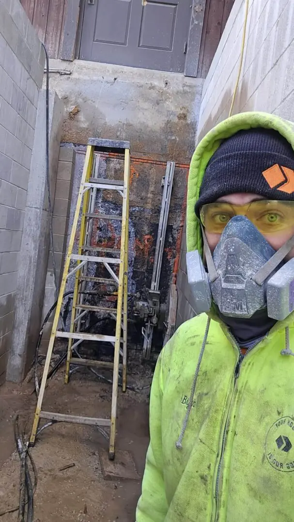 Worker in protective gear near construction site.