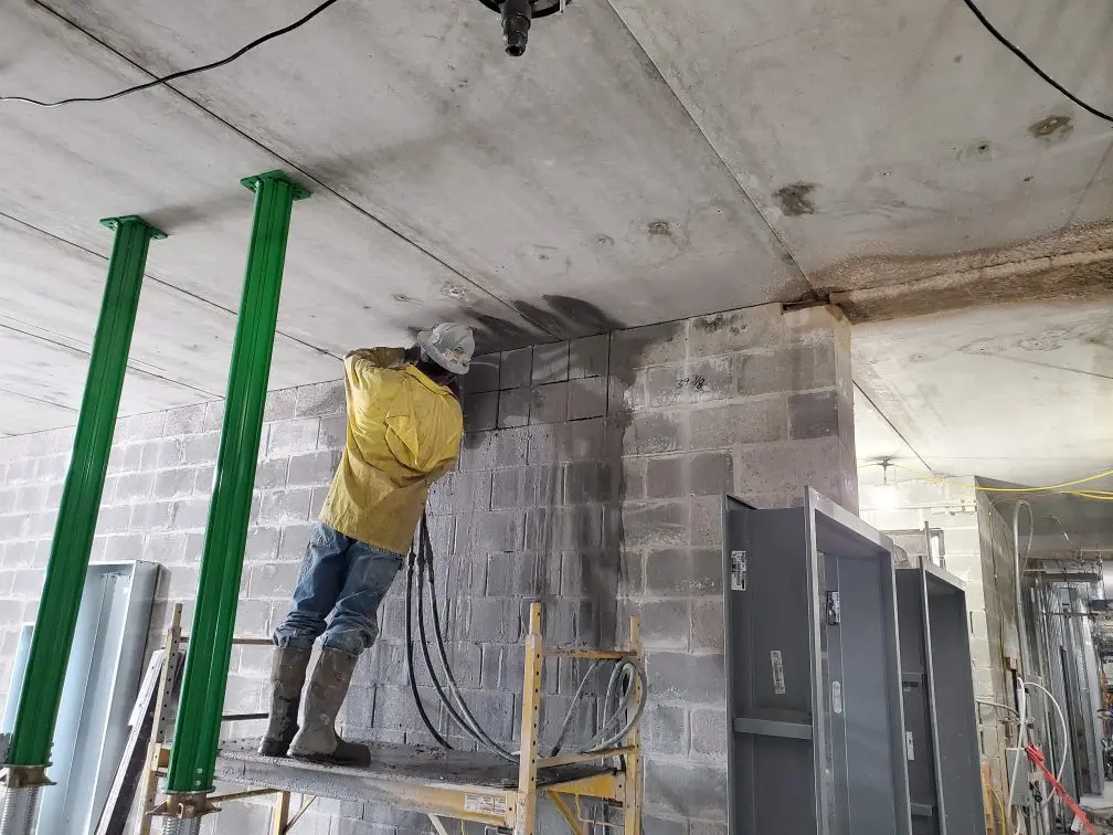 Worker repairing wall on construction site.