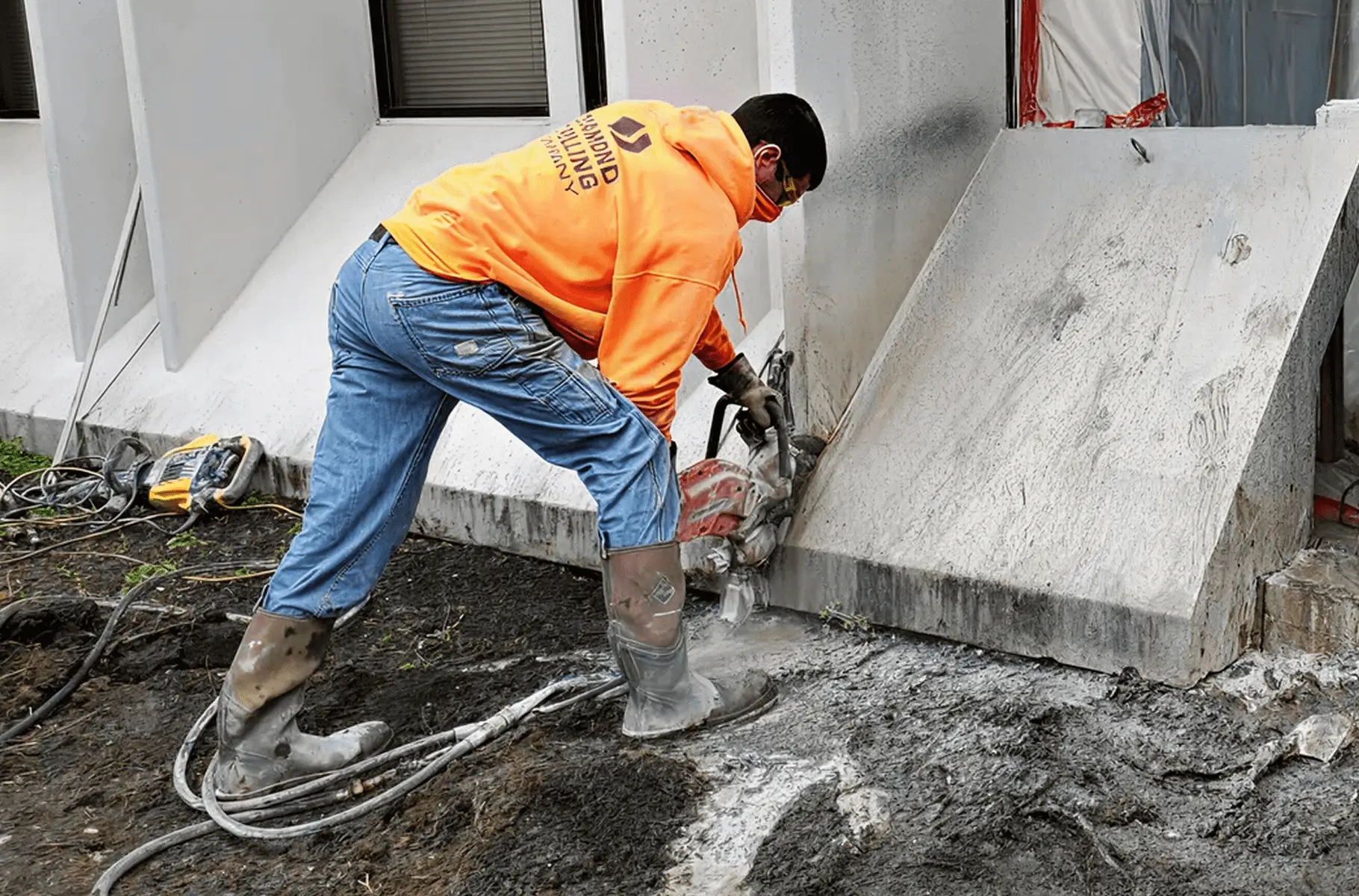 Worker cutting concrete with a power saw.